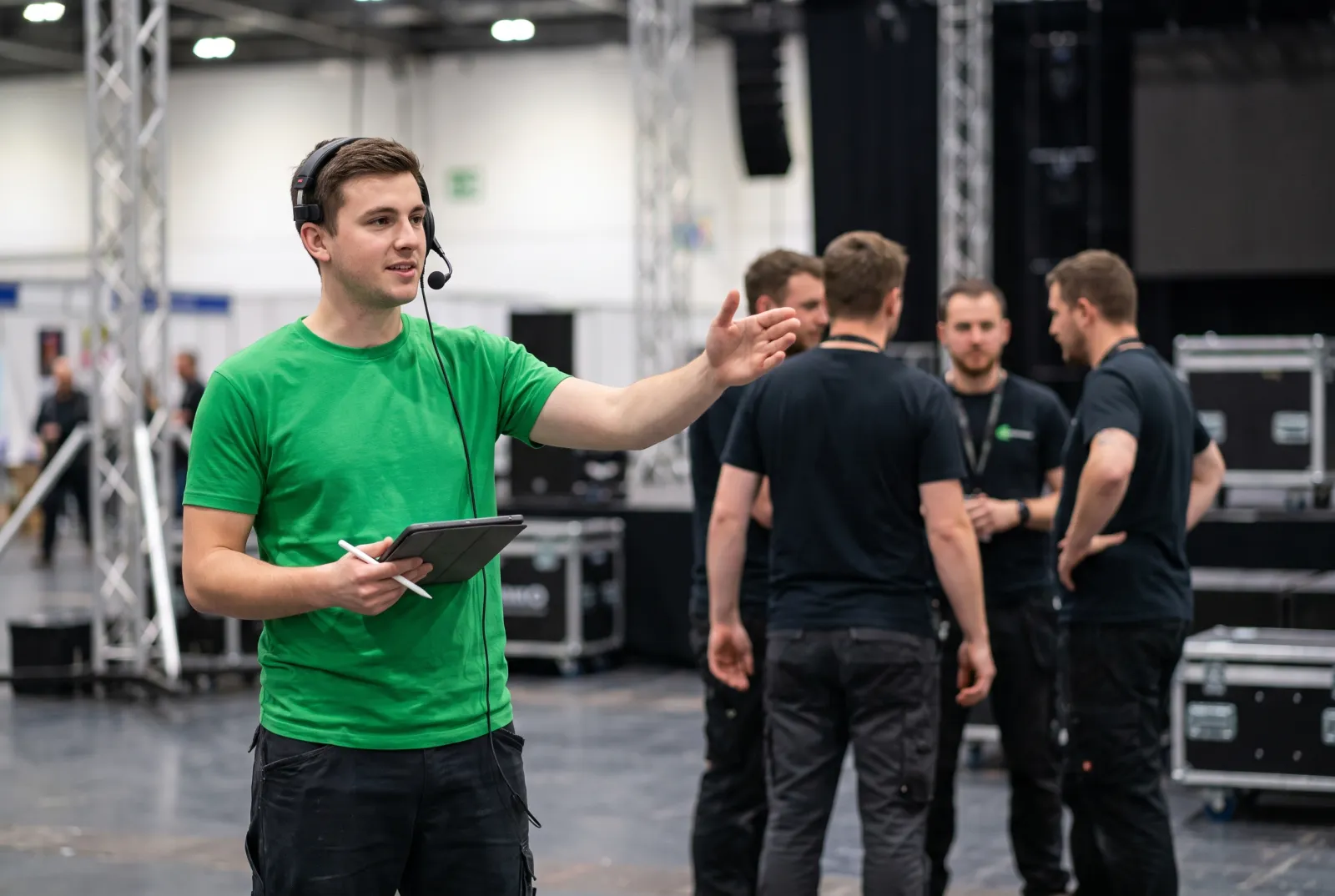 Crew Chief mit Headset weist das Aufbau-Team bei einer Veranstaltung ein bei uniworks